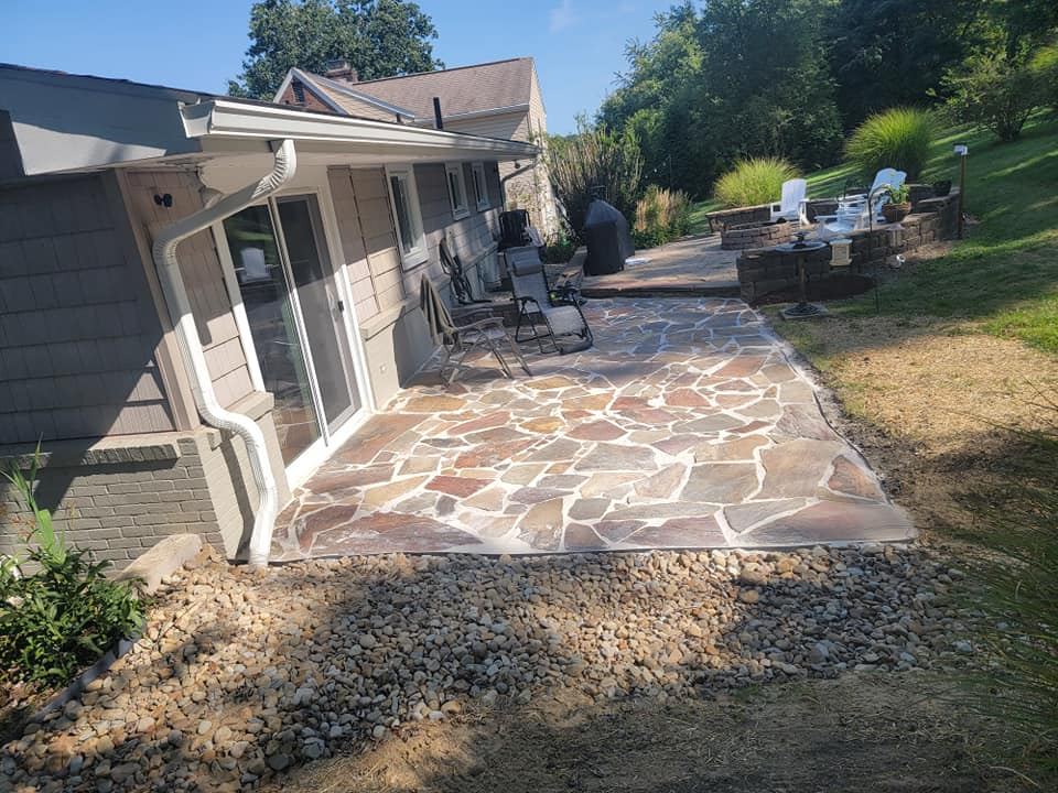 Flagstone patio with a river rock drainage bed along the edge